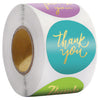Roll of colorful round thank you stickers with gold lettering on a white background
