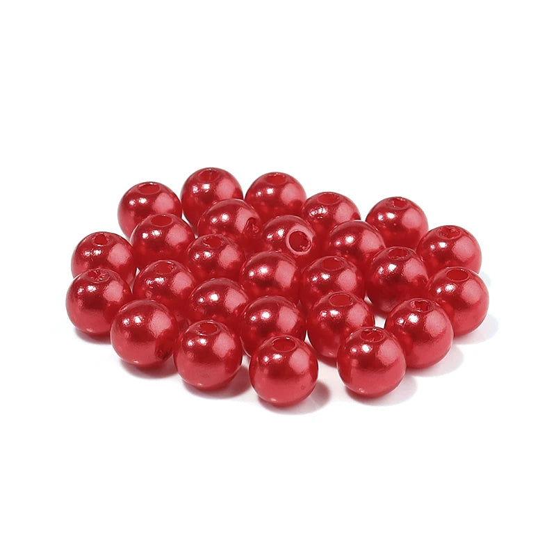 A pile of bright red, spherical imitation pearl beads for DIY jewelry making.