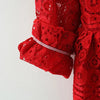 A close-up of a red lace princess dress for a toddler girl featuring a doll collar and ruffled sleeves.