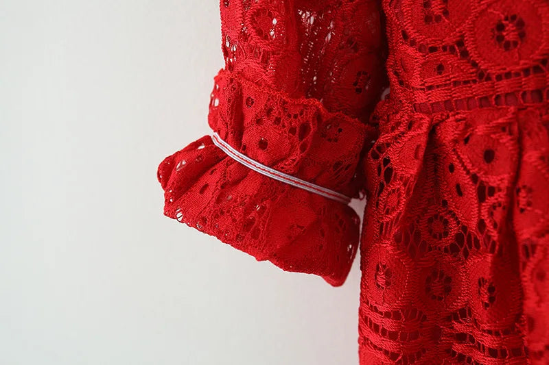 A close-up of a red lace princess dress for a toddler girl featuring a doll collar and ruffled sleeves.