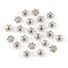 A collection of small, silver-toned Tibetan style hollow flower bead caps for jewelry making.