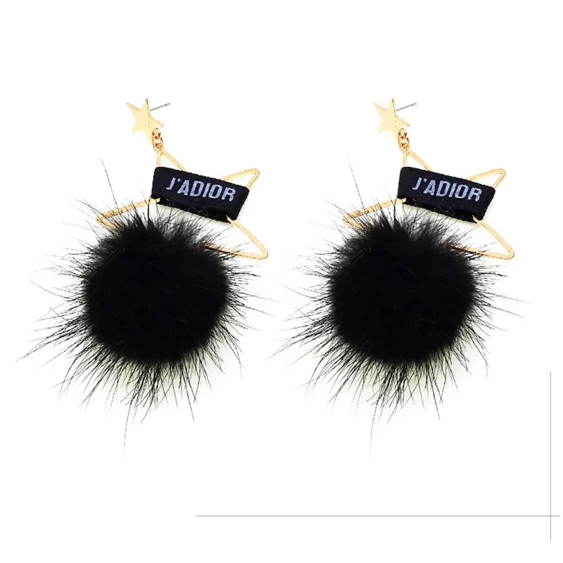 Pair of black mink fur pom poms with gold accents for crafts and accessories