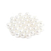 A pile of small, white imitation pearl beads for DIY jewelry making.