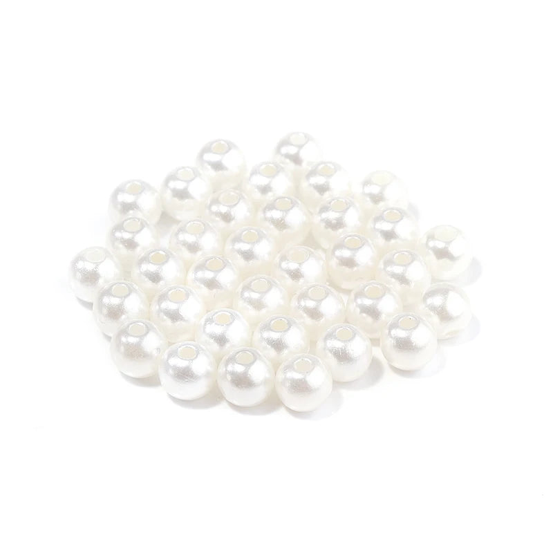 A pile of small, white imitation pearl beads for DIY jewelry making.