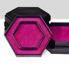 A black storage box with a hexagonal tray featuring a vibrant magenta velvet interior.