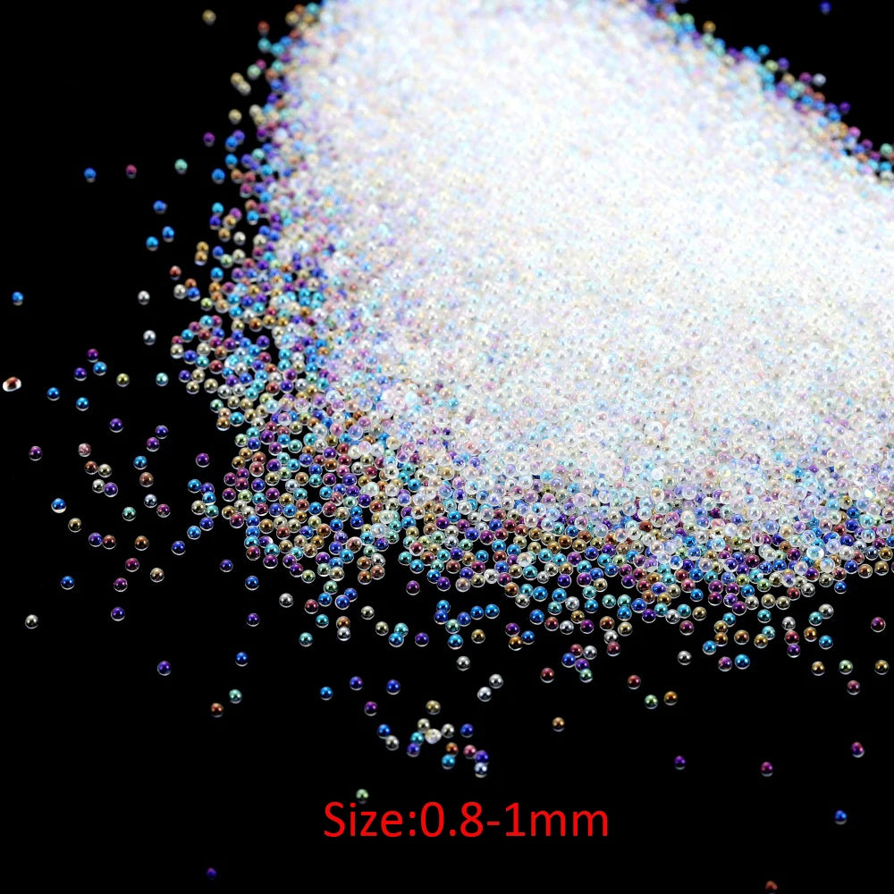 A pile of tiny, iridescent glass bubble beads ranging in size from 0.8 to 1 millimeter.
