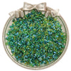 Un récipient en verre transparent rempli d'un mélange de perles de graines vertes et bleues, attaché avec un nœud.
