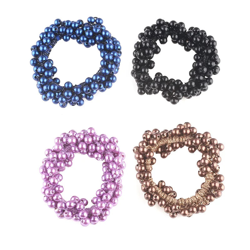 Four strands of elegant pearl hair ties or bow scrunchies in blue, black, purple, and rose gold.