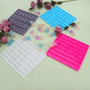 A collection of silicone mold tiles in purple, blue, and pink are arranged on a light green surface.