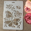 A white stencil featuring floral vine and butterfly designs for crafting projects.