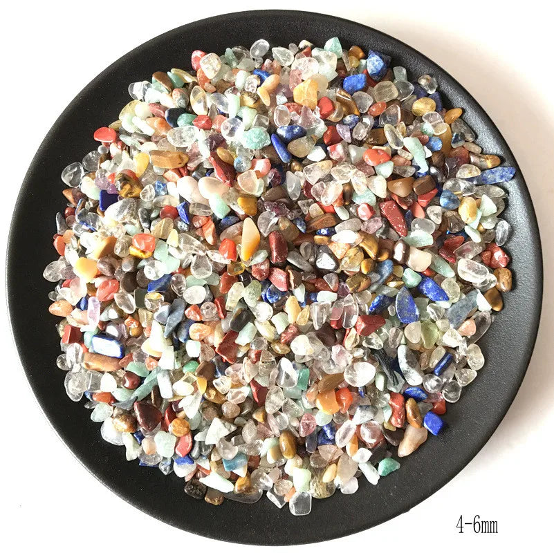A pile of natural mixed quartz crystal stones in various colors including clear, pink, blue, and amber.