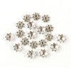 A collection of small, silver-toned Tibetan style hollow flower bead caps for jewelry making.