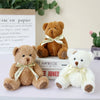 A collection of three adorable patch bear plush toys in brown, gold, and white, tied with light yellow ribbons.