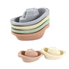 A set of five boat-shaped stacking cups for toddlers in various muted earth tones.
