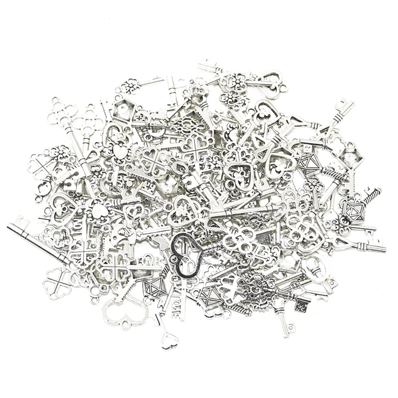 A pile of vintage metal key charms used for DIY jewelry making.