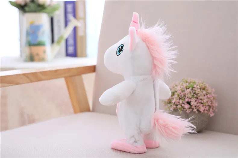 A white unicorn plush toy with pink accents sitting on a light-colored surface.