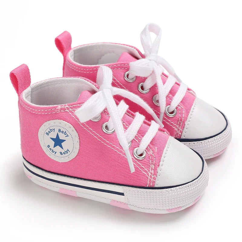 Pink canvas first walkers for infants with white laces and toe caps