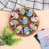 A collection of adorable sloth silicone beads in various pastel colors arranged on a woven tray.