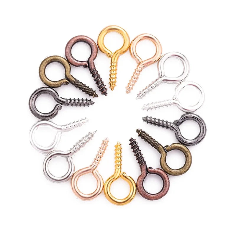 A collection of mini eye pins with screw threads for jewelry making in various gold and bronze tones.