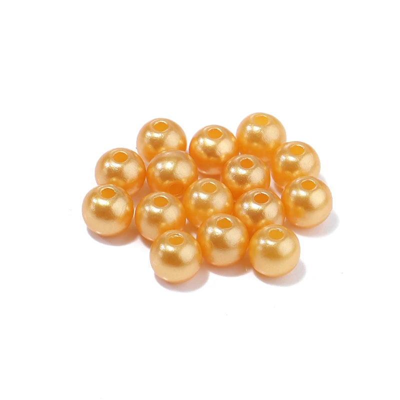 A cluster of small, round, golden-yellow imitation pearl beads for DIY jewelry making.