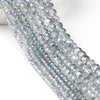 Close-up of silver iridescent faceted crystal glass beads arranged in a strand for jewelry making