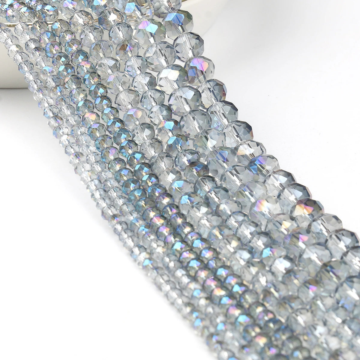 Close-up of silver iridescent faceted crystal glass beads arranged in a strand for jewelry making