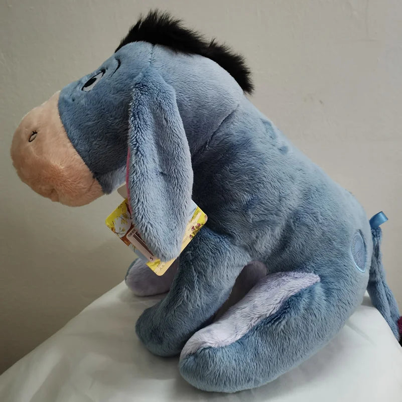 A soft blue Eeyore plush toy resembling a donkey is shown in a seated position.