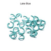 A pile of small, colorful metal open jump rings in a lake blue color.