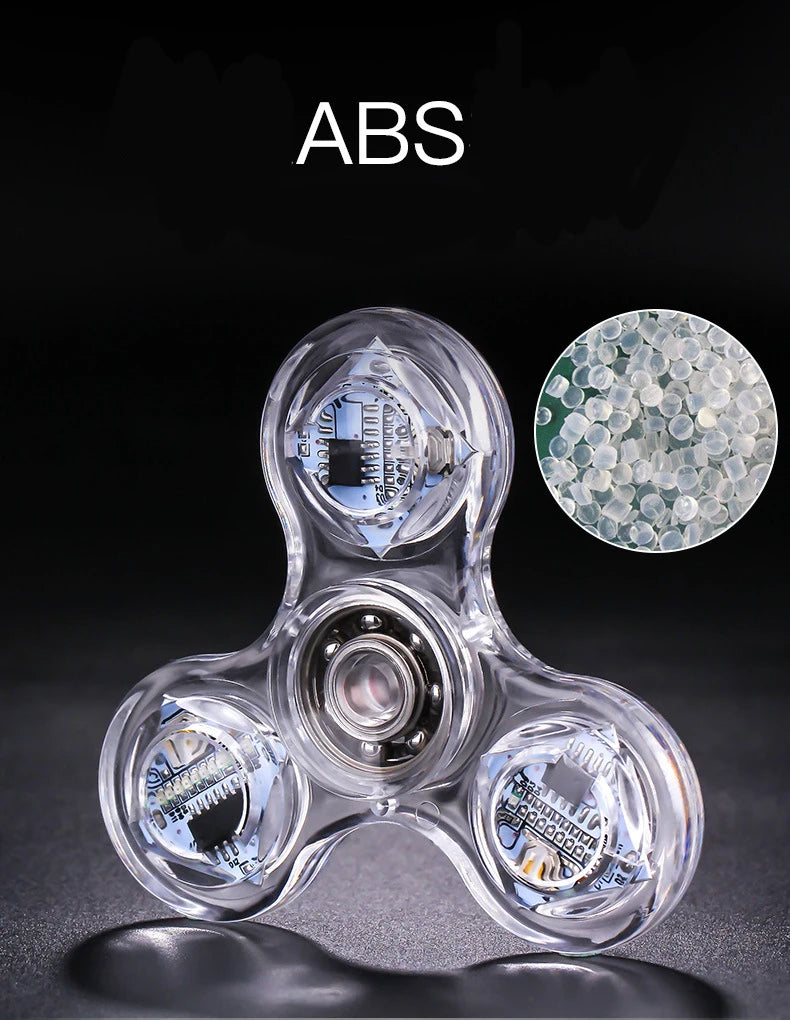 Clear ABS fidget spinner with LED lights and a glow-in-the-dark component, shown against a dark background.