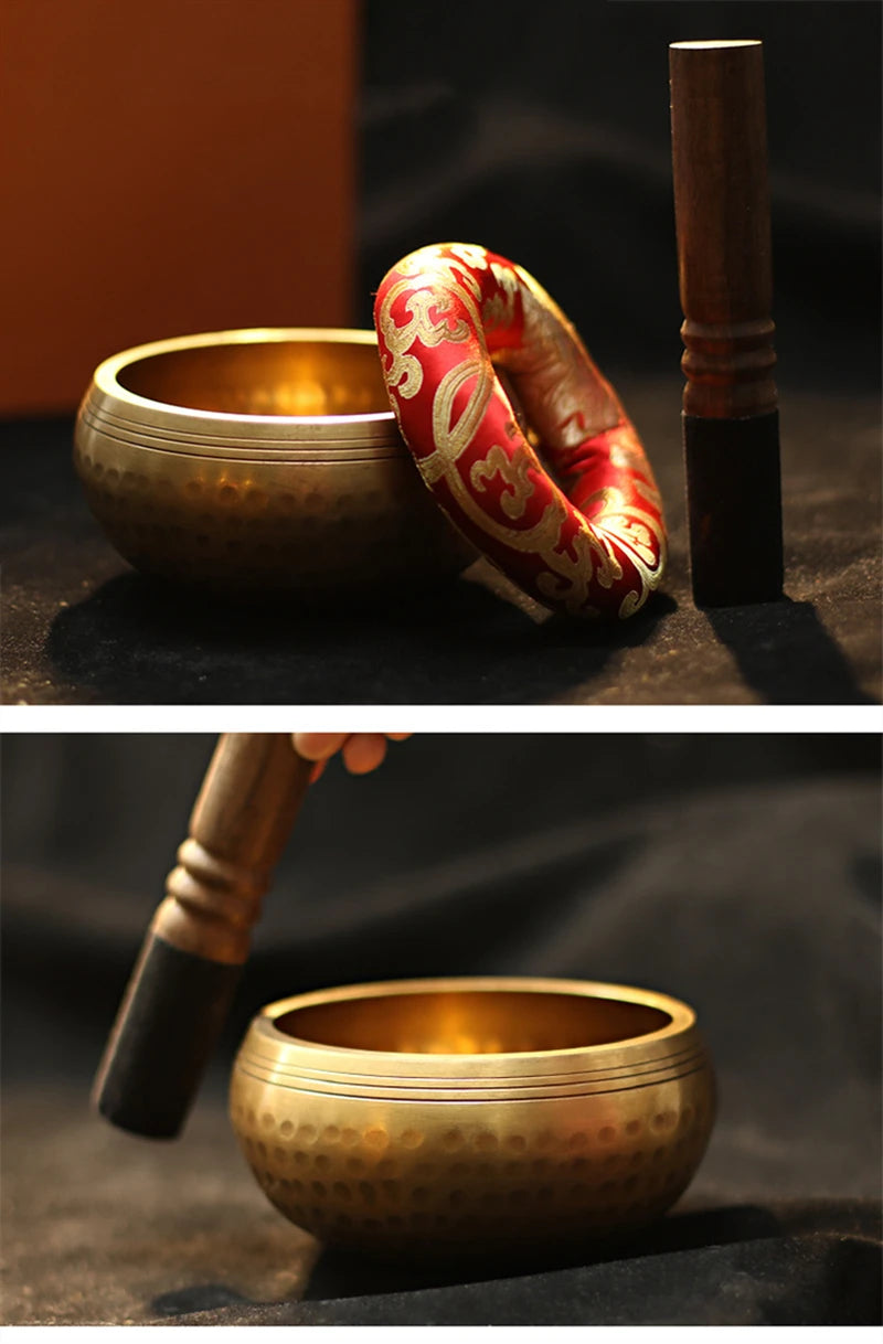 A handmade copper singing bowl and mallet resting on a dark surface.