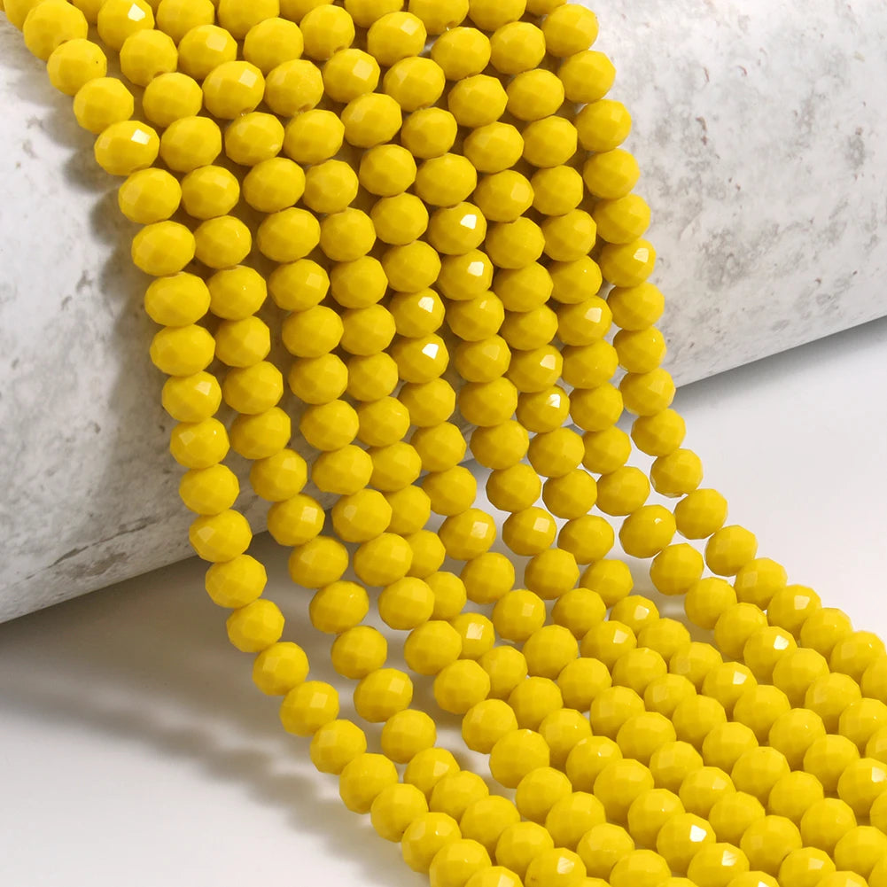 A close-up of a strand of bright yellow faceted crystal glass beads for jewelry making