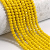 A close-up of a strand of bright yellow faceted crystal glass beads for jewelry making