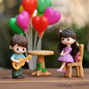 A set of musical couple figurines featuring a boy with a guitar and a girl, surrounded by heart-shaped decorations.