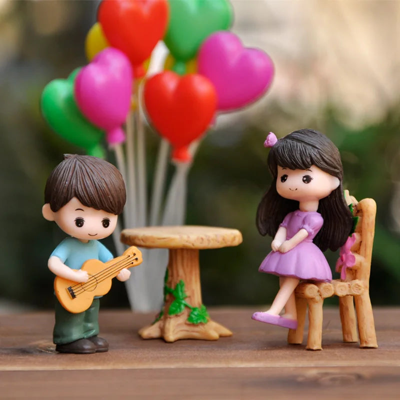 A set of musical couple figurines featuring a boy with a guitar and a girl, surrounded by heart-shaped decorations.