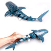 A teal and white patterned shark toy is held by a hand against a white background.