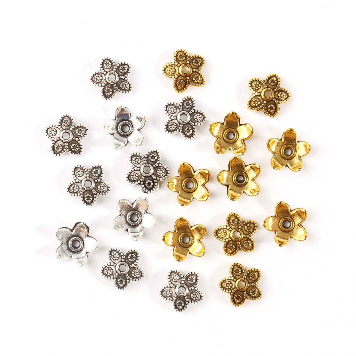 A collection of small, antique gold and silver Tibetan style hollow flower bead caps for jewelry making.