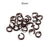 A pile of brown metal open jump rings for DIY jewelry making.