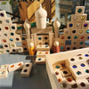 A collection of wooden gemstone building blocks and acrylic crystals arranged in various structures.
