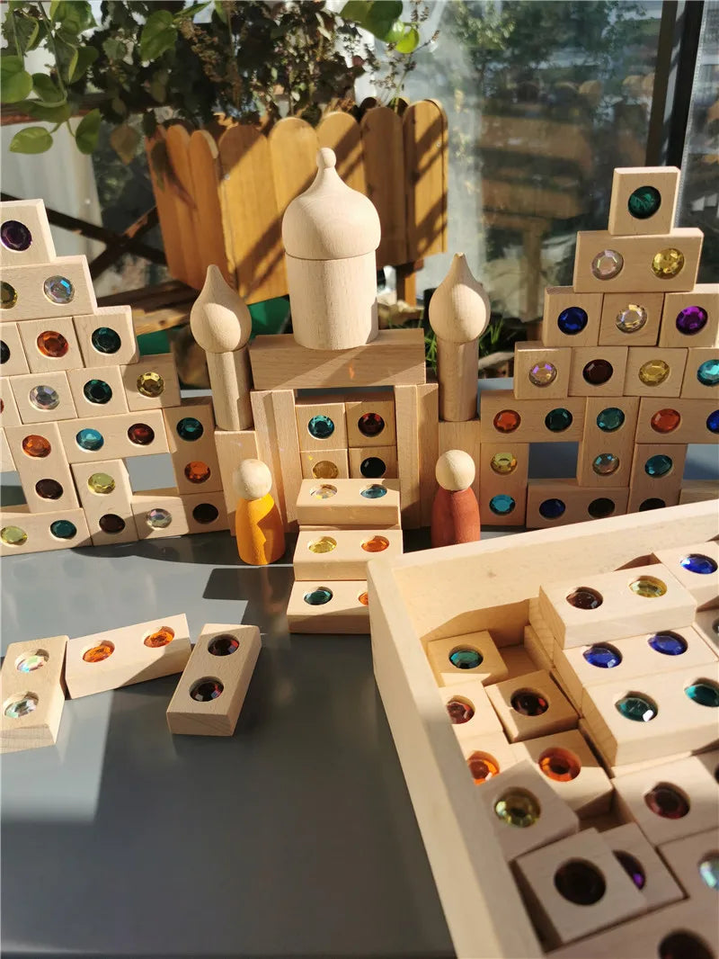 A collection of wooden gemstone building blocks and acrylic crystals arranged in various structures.