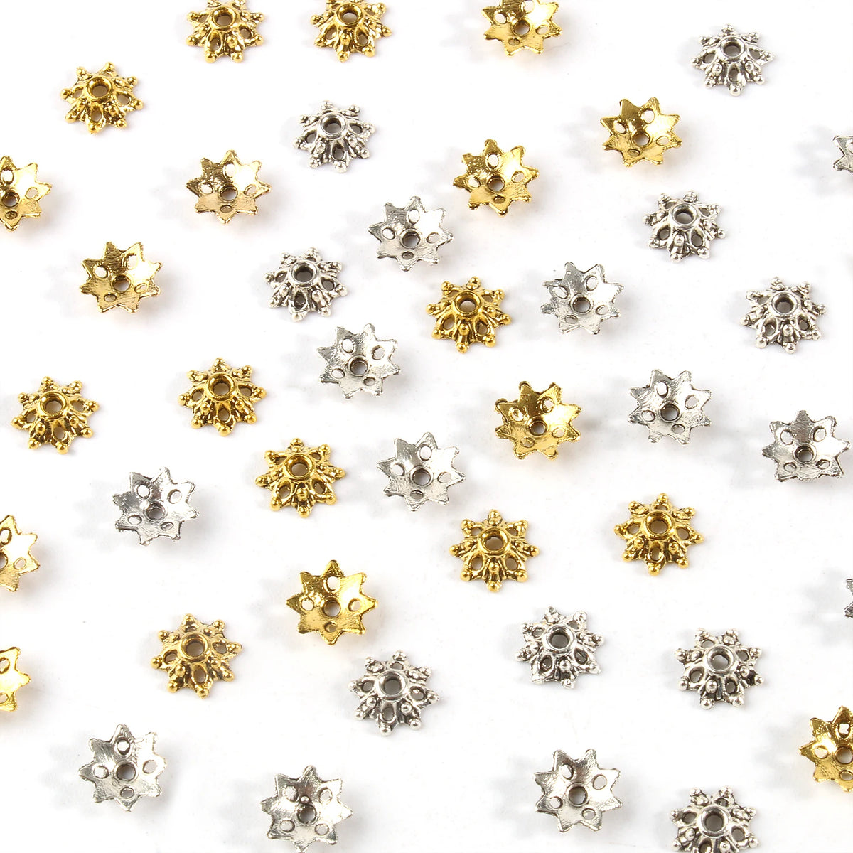 A collection of small, gold and silver Tibetan style hollow flower bead caps for jewelry making.