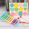 Wooden Montessori sensory blocks in various pastel colors and shapes arranged on a light wooden board with wooden sticks.