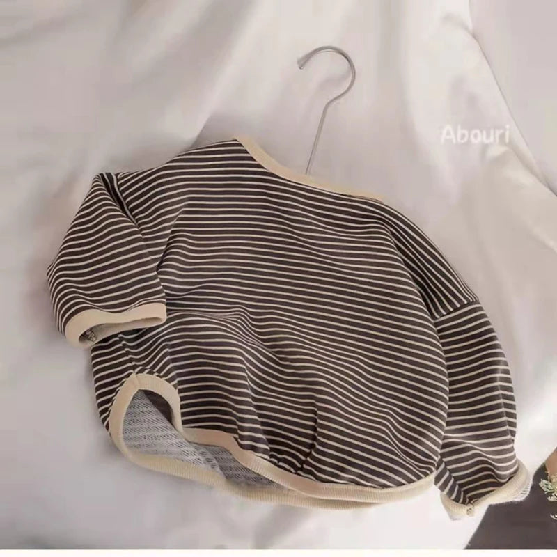 A black and beige striped kids cotton pullover sweatshirt hanging on a hanger.