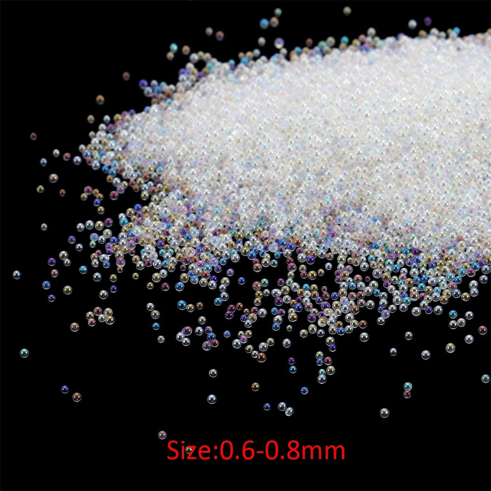 A pile of small, iridescent white and clear glass bubble beads ranging in size from 0.6 to 0.8 mm.