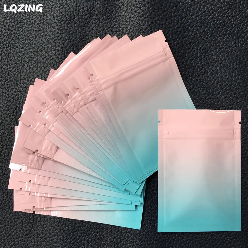 A stack of translucent pink and blue mini reusable ziplock bags are displayed on a dark surface.