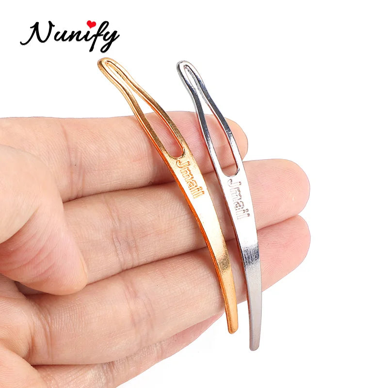 A pair of stainless steel interlocking needles for jewelry maintenance are shown in a hand.
