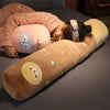 A person is lying down with a pink knitted sweater, resting their head on a long, light brown stuffed animal plush pillow dec