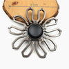 A metal fidget spinner with a rainbow finish is shown resting on a wooden surface.