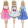 Three blonde dolls wearing pink, white, and blue striped dresses with bows