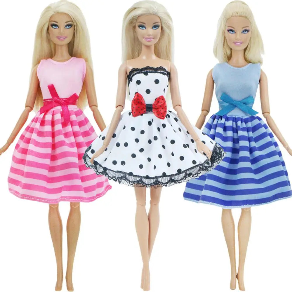 Three blonde dolls wearing pink, white, and blue striped dresses with bows