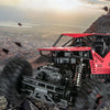 A red 4WD remote control stunt car is driving off-road over rocky terrain under a dramatic sky.